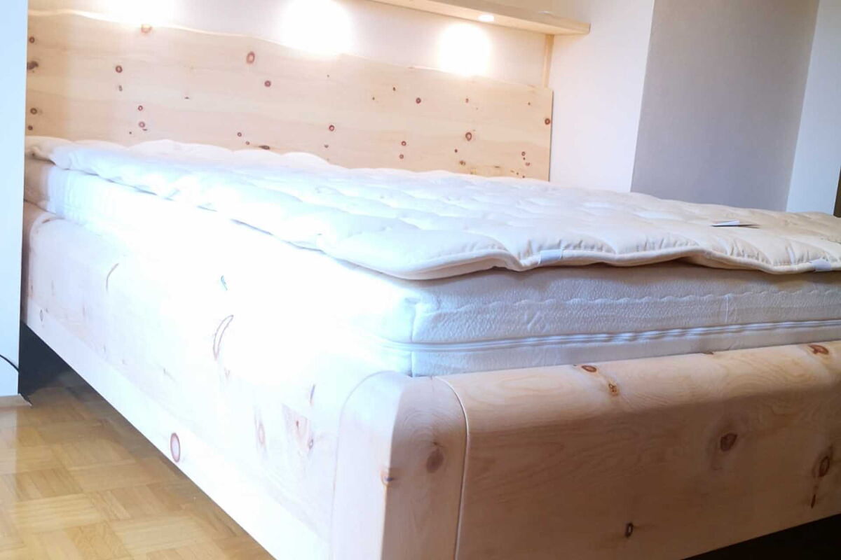Zirbenbett Linderhof mit Beleuchtung über Bett